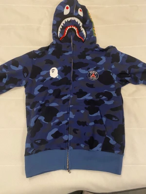 Bape x psg full zip - Säljer nu min helt nya bape x psg full zip tröja i storlek m. Aldrig använd, säljer för att den inte används eller kommer användas. Säljs billigt för jag vill bli av med den. (Pris kan diskuteras) fler frågor eller bilder så skriv