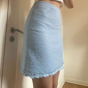 Söt babyblå y2k style kjol med ribbad kant och rhine stone detalj. Storlek S men den är väldigt stretchig så går säkert på M också 🥰