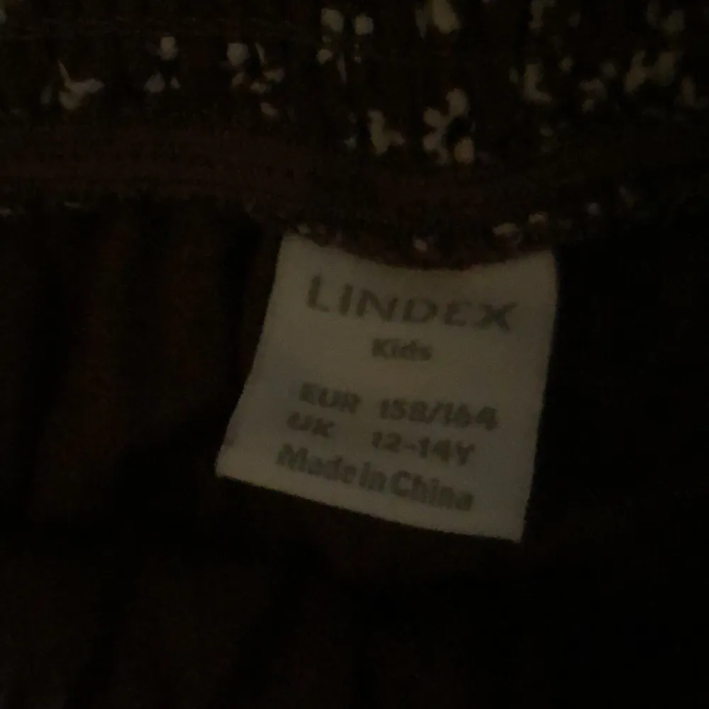 En brun blommig kjol från Lindex i storlek 158-164. Det är en liten fläck på sidan som knappt syns. En liten del av tråden på en av volangerna är borta men sytt igen så den inte går upp ännu mer.Säljer den för den inte kommer till användning längre.😍. Kjolar.