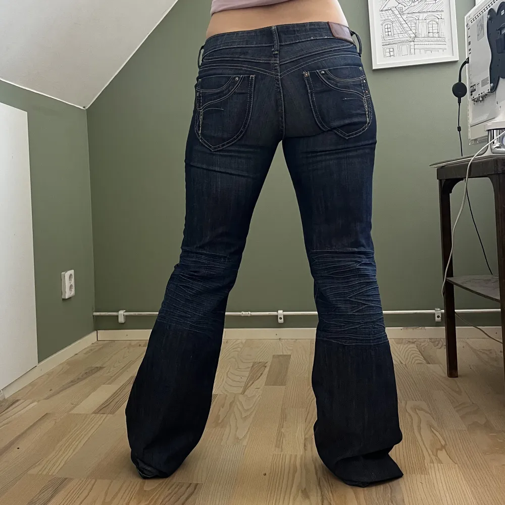 Superfina mörkblå lågmidjade bootcut jeans med fina detaljer!  Innerbenslängd: 84 cm midjemått: 82 cm  Jag på bilden är 160 cm, men på mig är jeansen för långa och de är därför uppvikta på bilderna  Skriv om du har fler frågor💕. Jeans & Byxor.