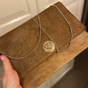 Väska med gulddetaljer - Väska med guldkedja och spänne med vridöppning. Inköpt på Sfera i Spanien - oanvänd. 