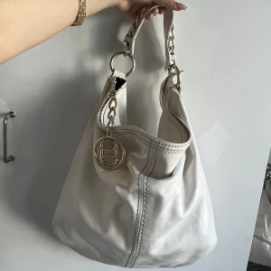 bebe väska  - Äkta bebe väska. Vit läder med guld detaljer. Inget av guldet är missfärgat men lädret är lite smutsigt men går att tvätta snabbt.❤️❤️❤️storlek 40 x 45 cm.