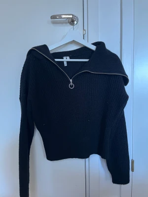 Stickad tröja - En svart stickad tröja från Nelly.com. Svår att visa på bild men har en ganska lång krage med dragkedja så hänger fint över axlarna, fint skick. 