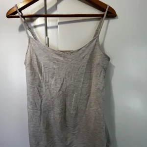 Linne  - Ett grått/vitt linne i storlek M. Använt skick lite små hål men inget man lägger märke till. Kan skickas med frakt, Swish betalning. 