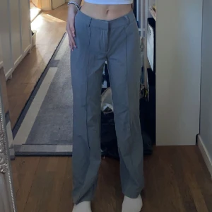 Grå kostymbyxor  - Mid Waist Kostymbyxor Utan Fickor - Hazel Grey Melange storlek 32/regular från madlady. Passar ca 160-166 långa. Nyskick använda en gång. Nypris 599 säljer för 450. Säljer då de inte sitter så tajt som jag önskar. Köpare står för frakt.