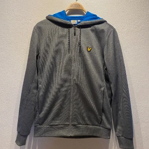 Grå Hoodie-Lyle&Scott - Grå hoodie med dragkedja från Lyle&Scott. Helt i nyskick och aldrig använd. Storlek M