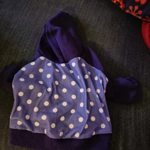 Lila, prickig hundtröja med luva - Ca 26cm ryggmått. Nedre mudden ca 60cm runt. Aldrig använd, men har blivit tvättad 