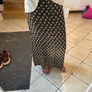 Långkjol - Svart lång kjol, med vita blommor. Bra skick.