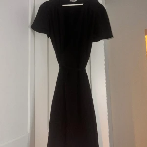 Klänning med volang detaljer - Svart kortärmad klänning med volang detaljer, den andra bilden är en bild som klänningar liknar det är alltså inte klänningen jag säljer, klänningen ser exakt ut som den fast med korta ärmar. Oklar storlek men passar 36/38