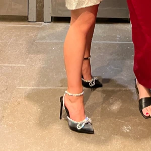 Klackar med glitterrosett - Svarta klackskor med en strassrosett. Endast använda en gång så jättebra skick! Perfekta till jul/nyårsfesten!! 💞Stl 36