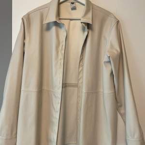 Går att ha som skjorta men jag har använt som overshirt/jacka med den uppknäppt. Superfin ljus beige färg. 