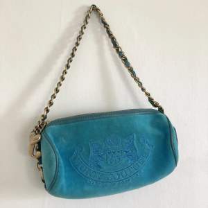 Jättesnygg liten turkos/blå handväska från Juicy Couture. Två pyttesmå fläckar på baksidan annars väldigt bra skick.