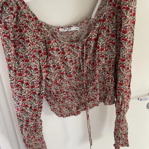Blus NA-KD - Blommig blus med fina detaljer