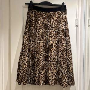 Plisserad kjol, leopardmönstrad i svart, beige, nougatbrun, stl 40 