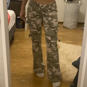 Lågmidjade cargos - 🌟PASSA PÅ ATT KÖPA INNAN GRATIS FRAKT FÖRSVINNER🌟Säljer dessa ascoola cargo byxor i camouflage!  De är lågmidjade och perfekt bootcut Tryck på köp nu💗  Midjemått: 36 cm Innerbenslängd: 79 cm