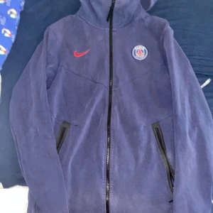 Två Nike fleece -  Den blåa är i storlek M och den svarta är i storlek L. Den blåa har några små hål men de är så små att de inte går att se. Den svarta är i dåligt skick men har inga hål men båda tröjorna har tappat färg eftersom de är gamla. 200KR FÖR EN 350KR FÖR BÅDA