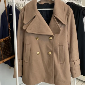 Filippa K kappa - Säljer min underbara kappa från Filippa K. Beige med guldknappar. Väldigt sparsamt använd, ca 2 gånger.  Köpt för 9000kr.  Stl. M men passar även S 