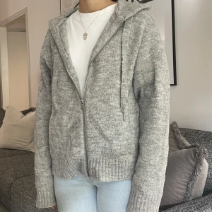 Grå zip up/ kofta - Grå stickad kofta från Hm med fickor och luva!