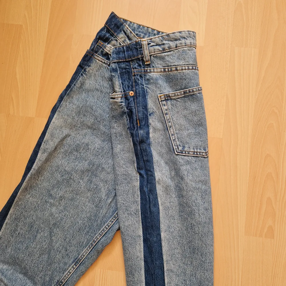 Mom jeans från monki i en tvättad blå färg, med mörkare blå ränder längs utsidan benet. Strl 30 enligt lappen (S/M).. Jeans & Byxor.