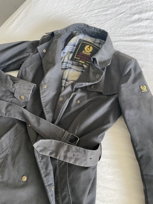 Belastar kappa  - Svart sotad Belstaff kappa i strö 44 vilket motsvarar en stel M.  Nypris 7500kr Säljes för 2500kr