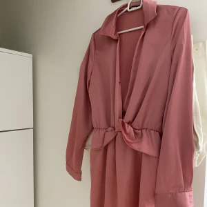Rosaklänning - Jättefin rosa klänning i lent och glansigt material. Inga defekter.