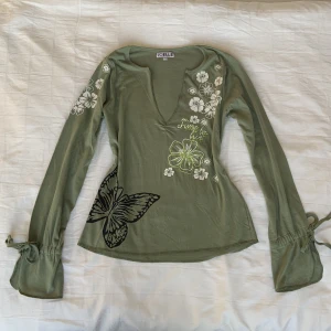 Y2k grön top!💋 - Y2k top med sött blomtryck och broderi! Den är v-ringad med snörning på ärmarna som går att reglera! Älskar denna tröjan såå och den är i jättebra skick utan några defekter!💋
