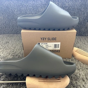 Yeezy slides  - Säljer nu dess as feta yeezy slidesen i storlek 43. Nypris 1800 mitt pris 900. Låda kommer med. Skick 10/10 aldrig använda. Möts upp i Stockholm eller fraktar spårbart via postnord📦