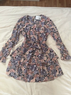 Ny blommig klänning  - Superfin chiffong klänning med resår i midjan som tyvärr aldrig kommit till användning, strl 44 men skulle säga att den passar 40-42 bättre 