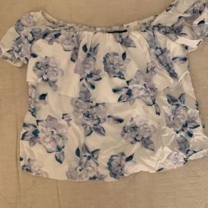 Volang tröja - En blommig tröja med volang upptill. Storlek xs men stor i storleken. 