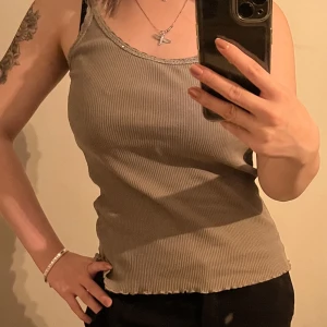 Långt linne - Olivgrönt längre linne. Vet inte storlek men själv brukar jag bära XS-S 