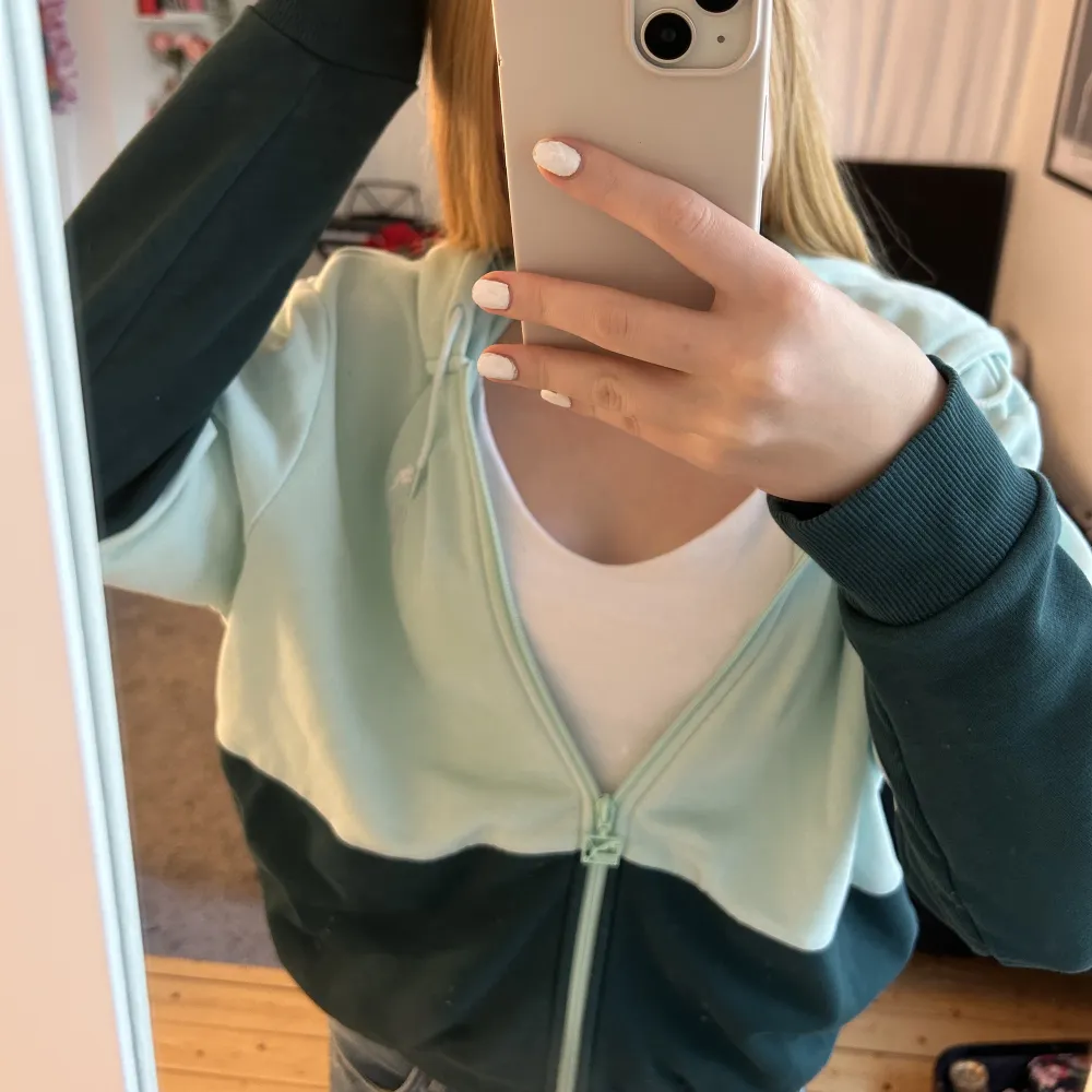 Säljer denna gröna och turkosa zip up hoodie från Puma. Den är i storlek M (jag har vanligtvis s/xs i mina kläder) Tröjan har inga tecken på användning.. Hoodies.