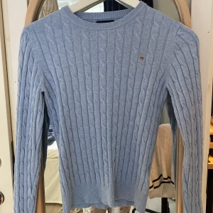Kabelstickad tröja GANT - Kabelstickad tröja från GANT. Ljusblå och köpt på NK i Stockholm. Storlek XS och passar mig som är 157cm. Stretch i materialet. 