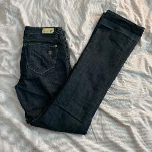 Lågmidjade jeans, som är lite utsvängda. Väldigt långa ben, så passar utmärkt om man är lite längre. Storlek 27 men passar på XS/S. Beninnerlängd 83 cm, midjebredd 2x38 cm, midjehöjd 21 cm.