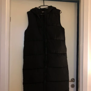 Dunväst - Lång dunväst i storlek XS. Köpt för två år sedan, sparsamt använd. En liten rispa i tyget, se på bilden.