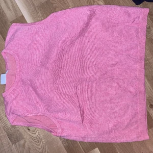 Väst - Rosa stickad väst från Saint tropez i storlek L. Sitter löst och fint att ha över en skjorta eller liknande. Ganska hög halsringning. Använd fåtal gånger i ny skick. Nypris 349 kr