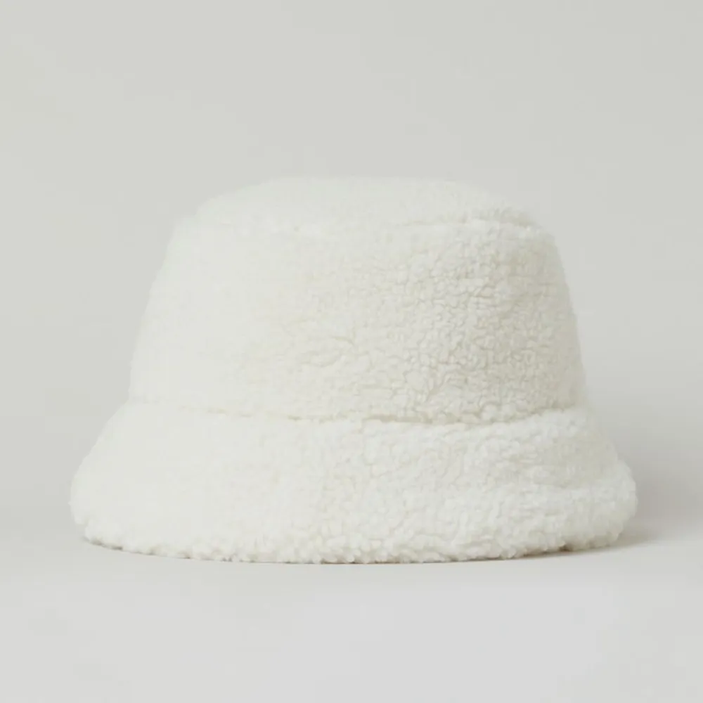 Ny mössa i bucket hat modell i vit pile. Köpt på H&M förra året. Ej använd. Mått: 60cm. Brättets bredd: 6cm. 🤍. Accessoarer.