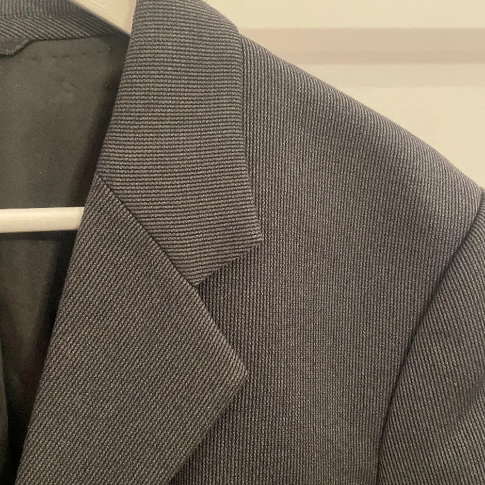Svart/antracit grå kavaj/kostymöverdel från Giorgio Armani i mycket bra skick.  Skön passform i Small/Medium.   Measurements: Lenght: 74 cm Shoulder width: 47 cm Sleeve length: 58 cm. Kostymer.