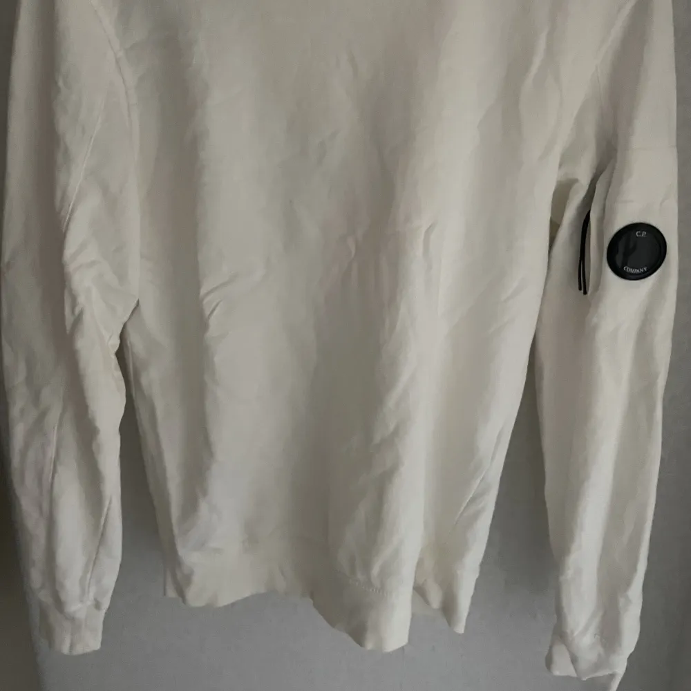 Klassisk college tröja från C.P Company i nyskick. Tröjan har märkets ikoniska lins på vänster arm och även en liten ficka. Tröjor & Koftor.