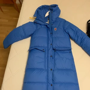 Fjällräven Expedition Long Down Parka W S Un Blue - Fjällräven Expedition Long Down Parka i storlek S, ljusblå säljes.   Endast använd ett fåtal gånger, kommer inte till användning. Inköpt 2021 på Outdoorexperten, kvitto finns självklart. Köparen betalar frakt. Kan även mötas upp.