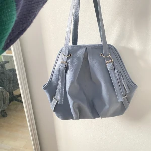 Väska - Blå väska med ett stort fack och med ett litet i det facket.