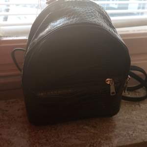 Nu säljer jag en fin liten svart min ryggsäck då den inte kommer till användning.Den är använd ungefär 2 gånger den har svart krokodil mönster. Skriv för fler frågor eller bilder