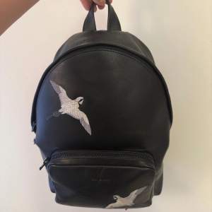 Axel Arigato ryggsäck tillverkad i äkta läder (2020). Denna stilrena väska är i använt skick med ett mindre slitage på sidan, som dock inte är synligt när väskan är stängd. Kvitto/fraktsedel och dustbag medföljer. Nypris då var 5500kr. Pris kan diskuteras