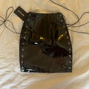 Lackskjol  - Supersnygg Lackskjol från Pretty Little Thing med snörning på sidorna. Säljer för att den är för liten på mig. Aldrig använd.