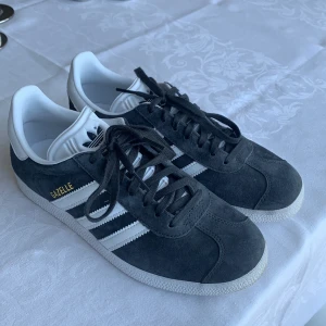 Adidas gazelle - Säljer dessa skorna i nyskick, som jag bara använt en gång. Säljs pga fel storlek.  Storlek: 38 Material; Mocca, läder Färg: Mörkgråa  Priset går absolut att diskutera 