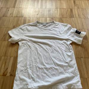 Calvin Klein Jeans T-shirt med en loggad patch på vänster arm.  Köpt för 450kr på Calvin Klein Köparen står även för frakten!