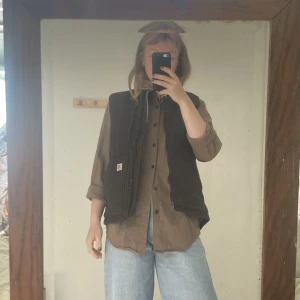 Carhartt väst - Brun mycket snygg praktiskt väst från carhartt. Väldigt lite använd och i mycket bra skick. Nypris ca 1100kr Skicka meddelande vid köp, PRIS INKLUSIVE FRAKT