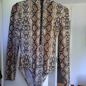 Body storlek small - Säljer min body från DennisM i storlek small. Sparsamt använd. Superskön och snygg med dragkedje detaljen! 