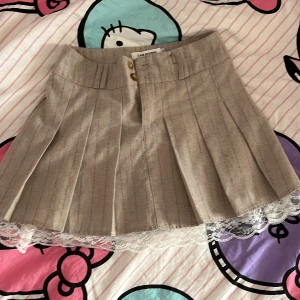 Beige plisserad kjol med vita saker - Säljer för att den är för kort oxh inte min stil! Används 2 gånger och har inga fläckar! Klicka på köp om du vill köpa, kontakta om du har frågor! 