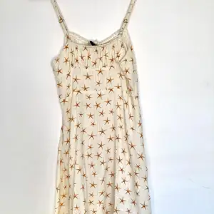 Petite klänning Storkel XS i vit linne, mönster med små sjöstjärnor. Använd en gång, säljer pga att den är för liten för mig.