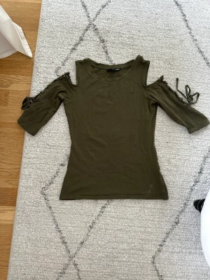 trekvartsärmad topp med snörning - cool topp med snörning och cutout på armarna. Köpt second hand men aldrig använd